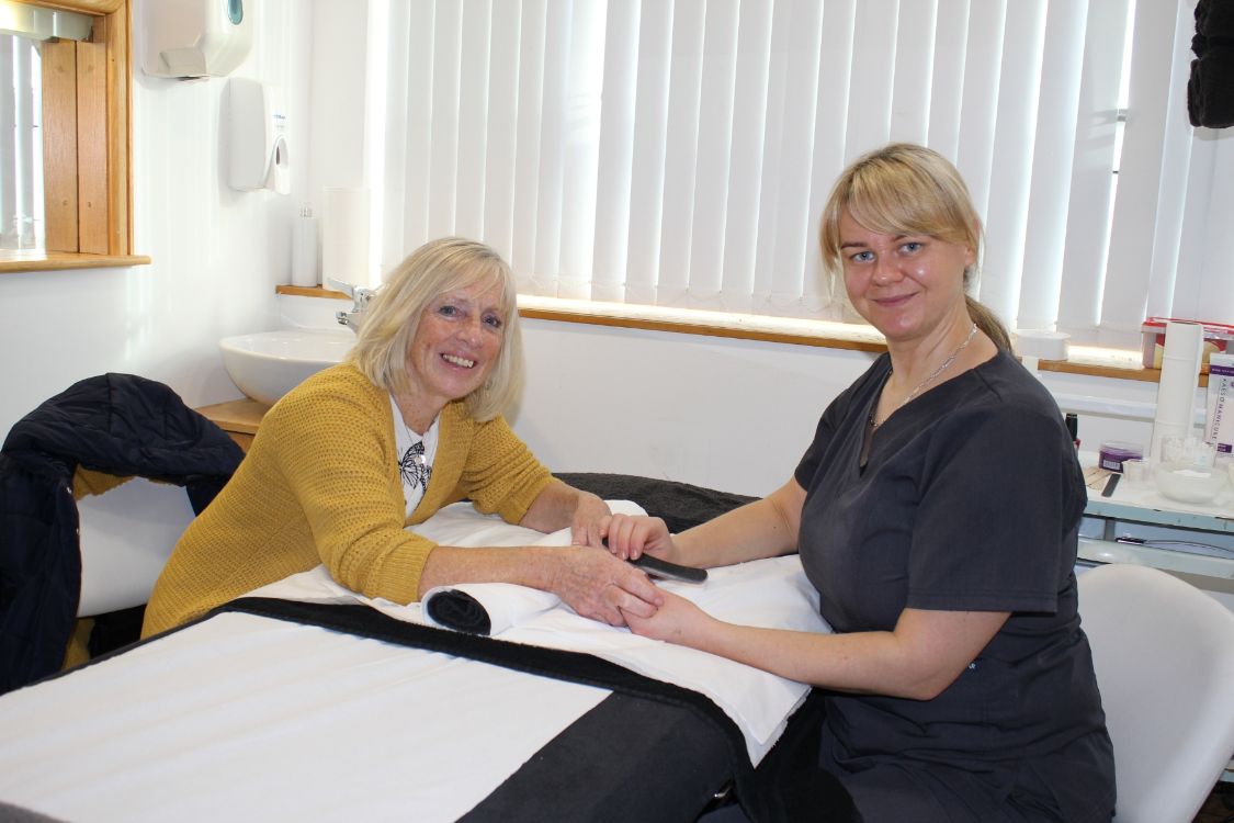 A client with a beauty student in salon.